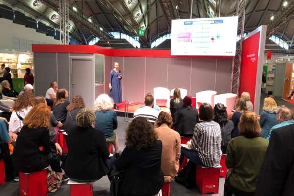 Sonja Oberndorfer hält auf einer Bühne vor Publikum in einer Halle der Frankfurter Buchmesse.